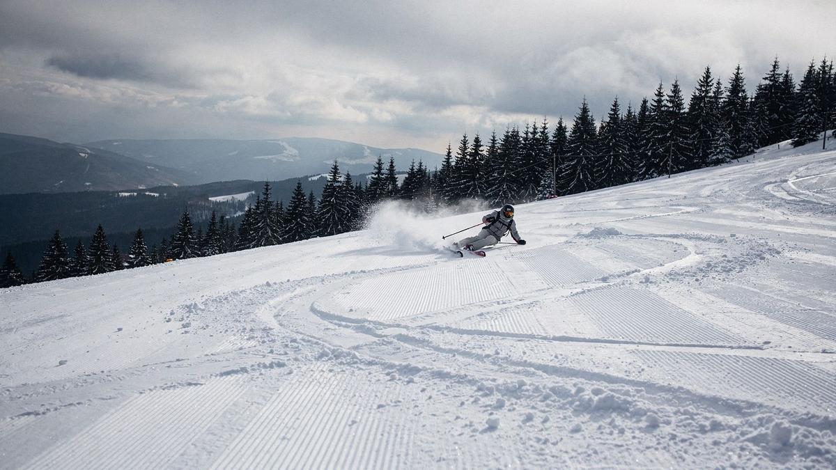 Skier descending a freshly groomed piste on a Carpathian ridge near Bukovel